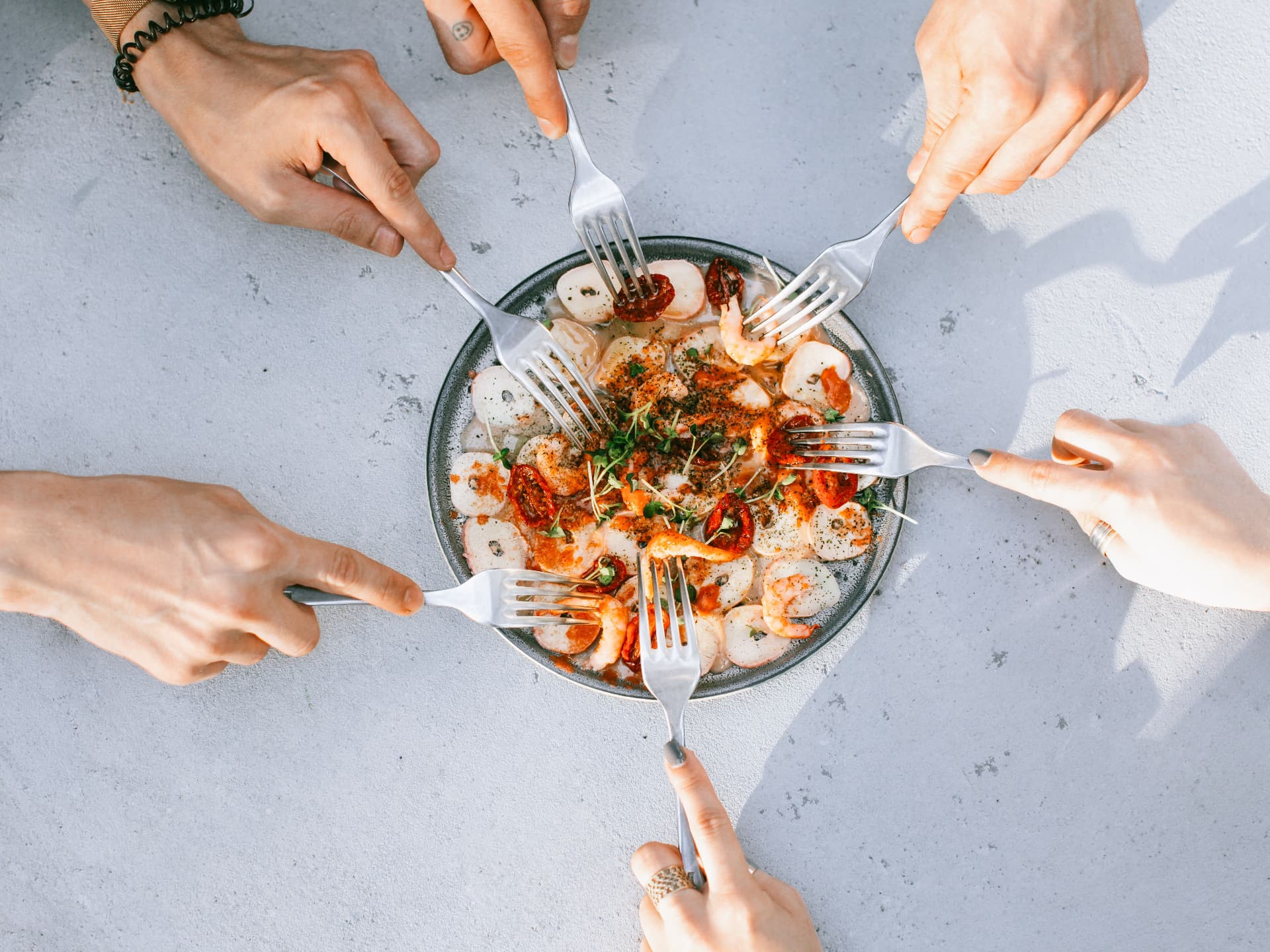Friends sharing a seafood plate from every side of the table