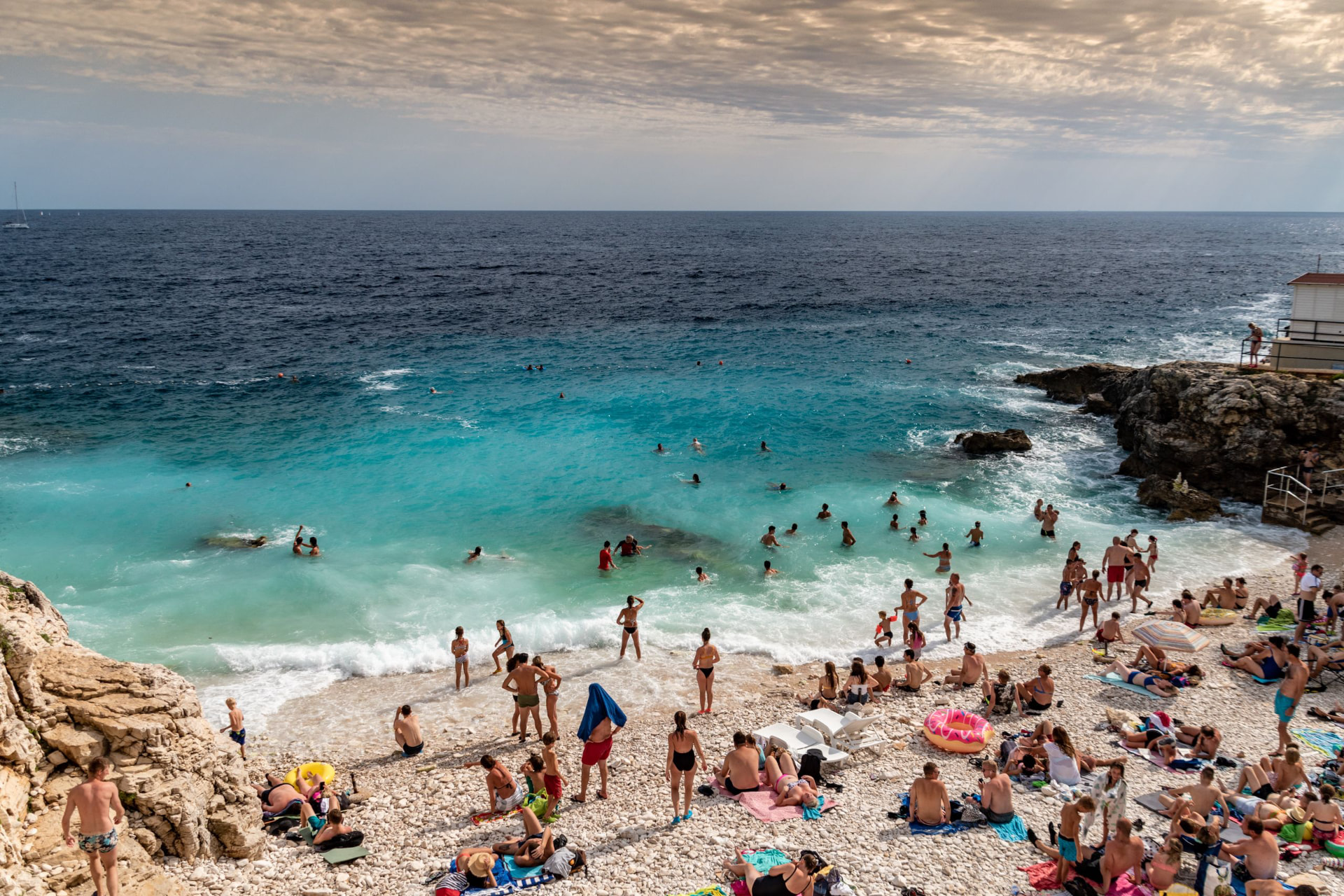 Hidden pebble cove with turquoise water at golden hour
